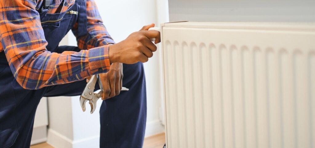 A man using tools to balance radiators in his home