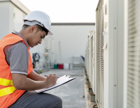 An energy assessor conducting a TM44 Air conditioning inspection.