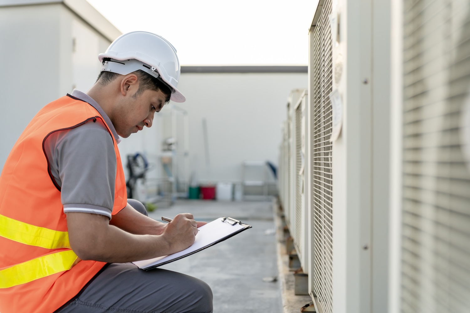 An energy assessor conducting a TM44 Air conditioning inspection.